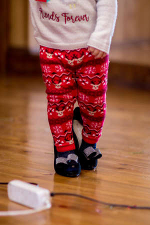Funny little girl in her mother's big shoesの写真素材