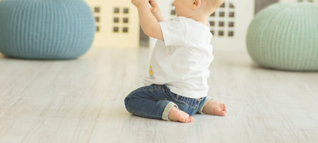 litle boy sits on the floor at bedroom