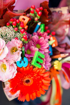Unidentified first grade school kids with flowers bouquet celebrate their first school day before going to classesの写真素材