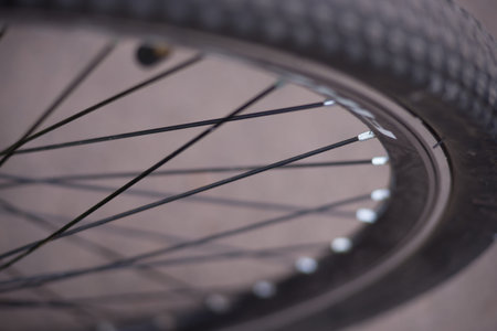 Axel and spoke section close-up of bicycle wheel in a cycle workshop. Shallow depth of field.