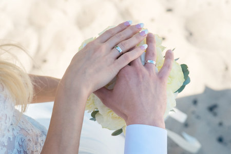 Young woman with bouquet of flowers on the summer beach.