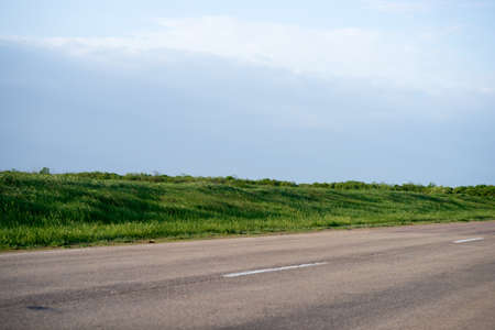 road in fields covered with green grassの写真素材