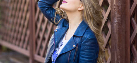 Portrait of happy girl with long wavy hair . Fair-haired model with curly hairstyle and fashionable makeup . Female model over braun background not isolatedの写真素材