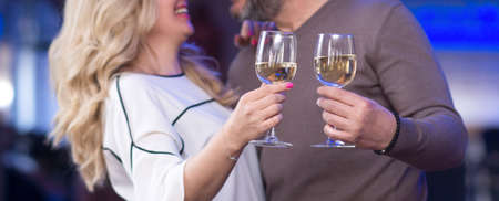 Close up two hands toasting champagne glassesの写真素材