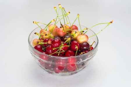 Cherries. Cherry. Cherries in color bowl and kitchen napkin. Red cherry. Fresh cherries. Cherry on white background. healthy food conceptの写真素材
