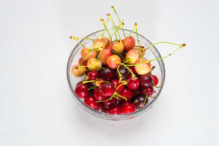 Cherries. Cherry. Cherries in color bowl and kitchen napkin. Red cherry. Fresh cherries. Cherry on white background. healthy food conceptの写真素材