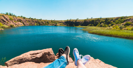 Travelers couple in sports shoes on a mountain near a river in the background of nature. Man and...