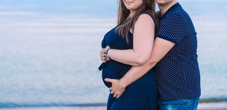 Romantic moments for pregnant couple on beachの写真素材