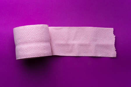 roll of pink toilet paper on a purple background gorizontalの写真素材