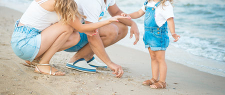 Close up Happy family of three - beatiful wife, father and daughter having fun walking on beach at...