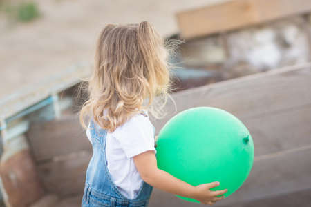 back view of girl holding ballon pointingの写真素材