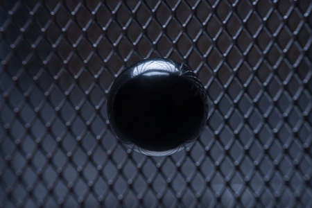 macro photo. metal ball on the background of iron grating, side viewの写真素材