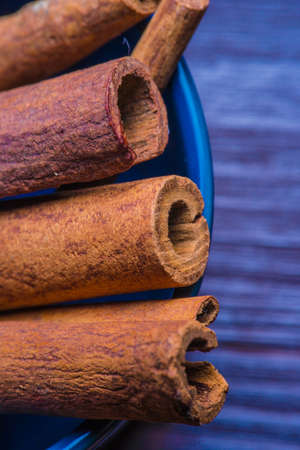 cinnamon sticks on blue wooden background macroの写真素材