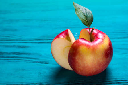 cut ripe red apple lies on a wooden tableの写真素材