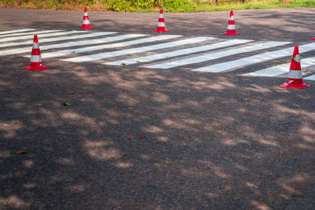 Road cones signal with two reflective stripes on the road with a pedestrian crossing. repair workの写真素材