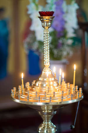 the believer puts a candle on the candlestick in the church, cathedralの写真素材