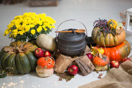 Table setting for Thanksgiving. Autumn table with pumpkins and candles. Big cooper pan with orange pumpkin soup.の写真素材