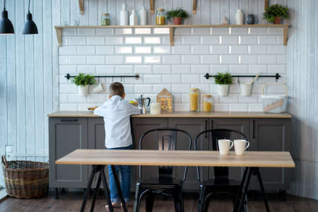 Cute boy child eating at the table in kitchenの写真素材