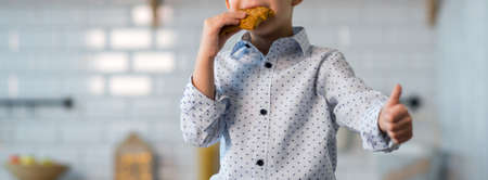 Cute happy boy, eating cookies and drinking milk or tea, waiting for Santa on Christmas Eveの写真素材