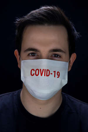 Man in a mask for protection with a print of Covid-19の写真素材