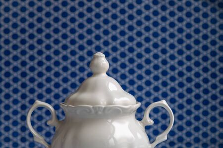 White sugar bowl. Unfocused blue geometric background.の写真素材