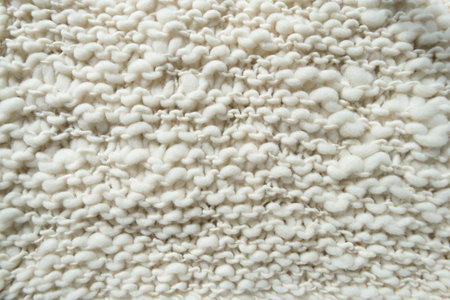 White knitted woolen fabric. Closeup.