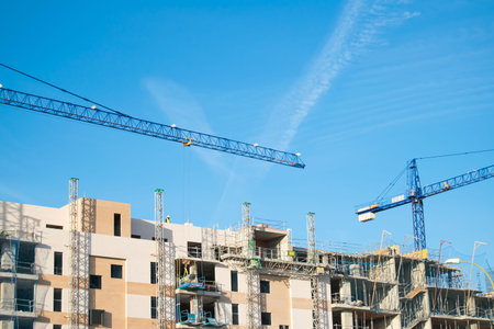 Crane, building under construction and blue sky.