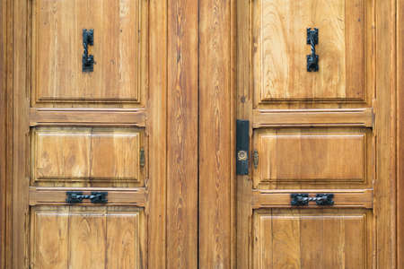 Old wooden door with black iron handle.の写真素材