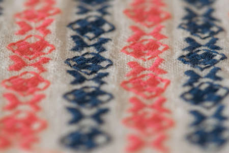 Embroidered pattern on cotton fabric. Fragment. Handmade. Selective focus.の写真素材