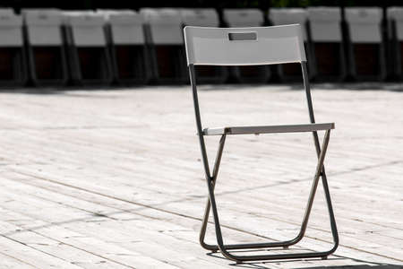 The folding chair with the metal case and a plastic seat mat and a back costs on a wooden floor from boards.の写真素材