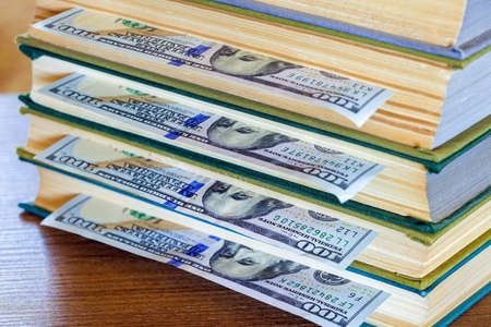 the denomination hundred dollars lie between pages of the book, saving hidden.の写真素材