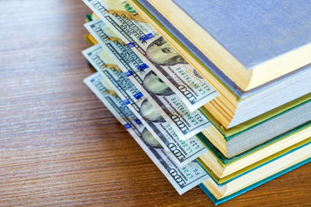 the denomination hundred dollars lie between pages of the book, saving hidden.の写真素材