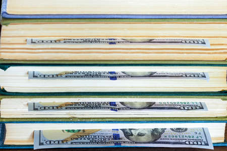 the denomination hundred dollars lie between pages of the book, saving hidden.の写真素材