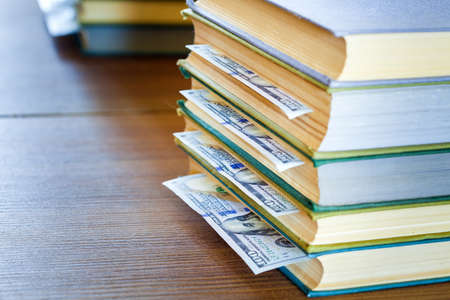 the denomination hundred dollars lie between pages of the book, saving hidden.の写真素材