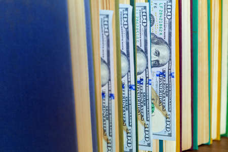 the denomination hundred dollars lie between pages of the book, saving hidden.の写真素材