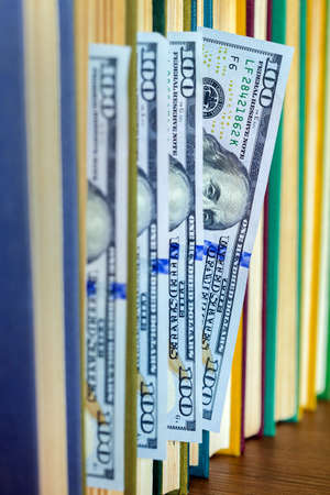 the denomination hundred dollars lie between pages of the book, saving hidden.の写真素材