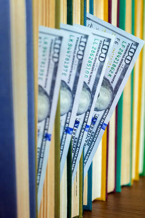 the denomination hundred dollars lie between pages of the book, saving hidden.の写真素材