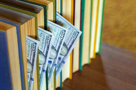 the denomination hundred dollars lie between pages of the book, saving hidden.の写真素材