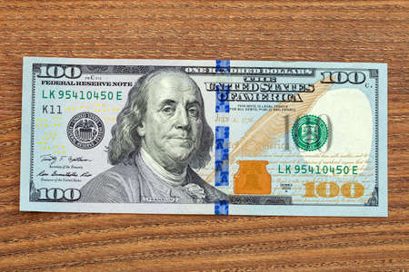 the denomination hundred dollars, on wooden table.の写真素材