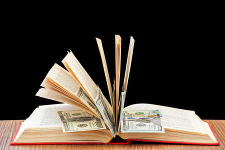 Money in the book, cash between pages of the book on a table.の写真素材
