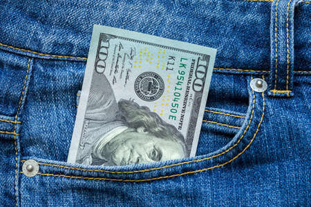 Money in a pocket, dollars looks out of a pocket of jeans.の写真素材