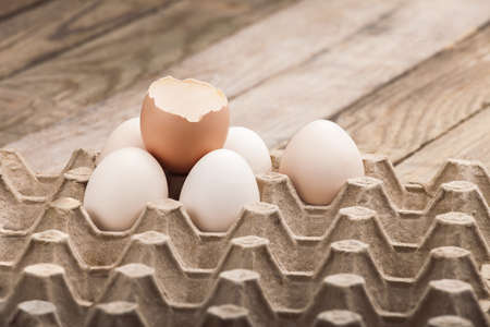 Eggs in a paper tray on a wooden table from old boards.の写真素材