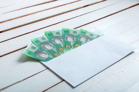 Cash in an envelope, the denomination of ukrainian hryvnia on a table from white wooden boards.の写真素材