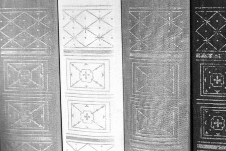 Old book firm cover close up side view, back of retro books.