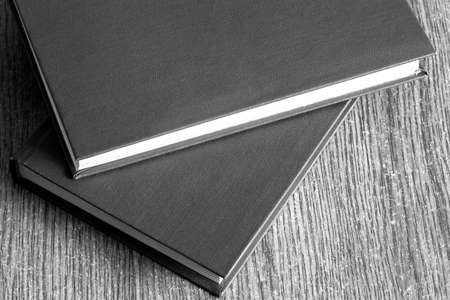 The book in firm cover lies on a table with wooden texture.の写真素材