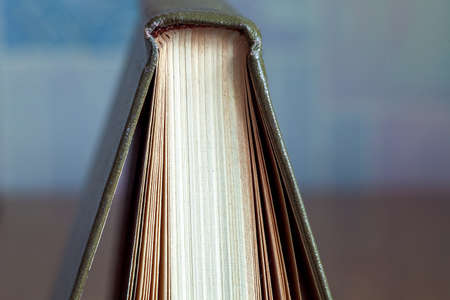 The book in firm cover lies on a table with wooden texture.の写真素材