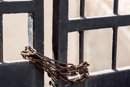 The gate of black, blocking rusty chain.の写真素材