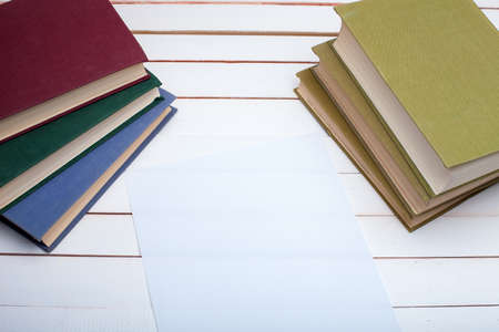 On a wooden table hardcover books and the sheet of paper.の写真素材