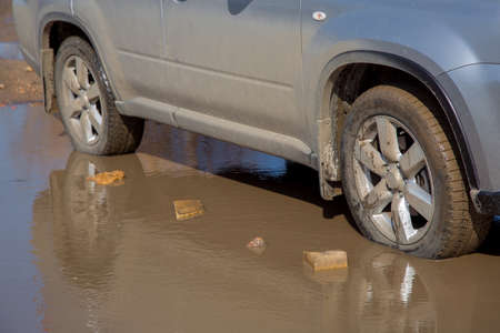 The car the SUV the jeep costs on the dirty earth road in the swamp.の写真素材