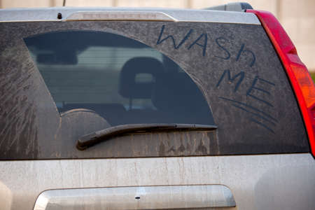 Dirty rear window of the car and inscription Wash me.の写真素材